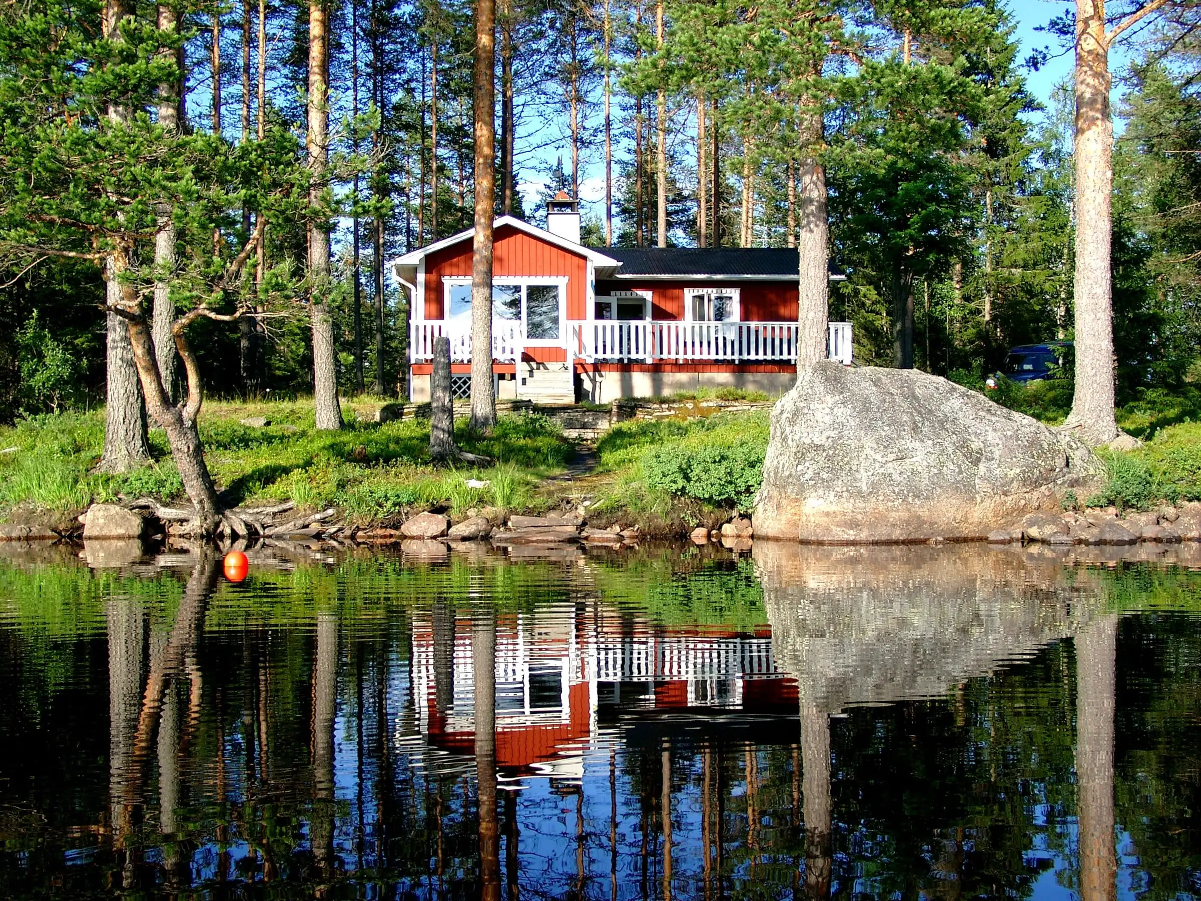 Den röda stugan vid Nissången speglar sig i sjön